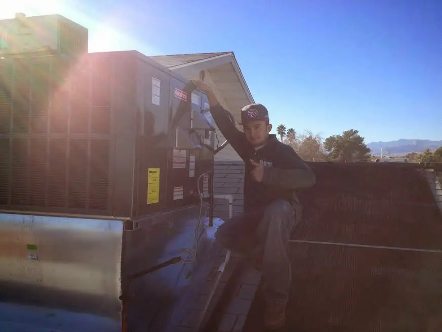 HVAC technician performing AC Tune-Up on a rooftop unit in Sans Souci